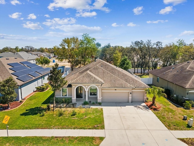 view of front of home featuring stucco siding, roof with shingles, concrete driveway, a front yard, and a garage