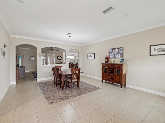 dining area with light tile patterned floors, visible vents, baseboards, arched walkways, and crown molding