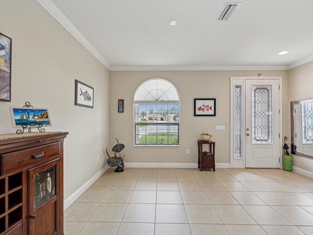 foyer with visible vents, a healthy amount of sunlight, light tile patterned flooring, and ornamental molding