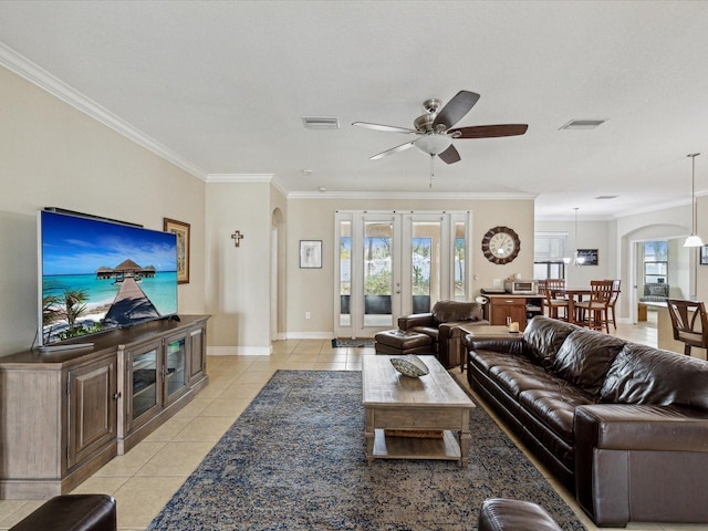 living room with light tile patterned floors, visible vents, and arched walkways