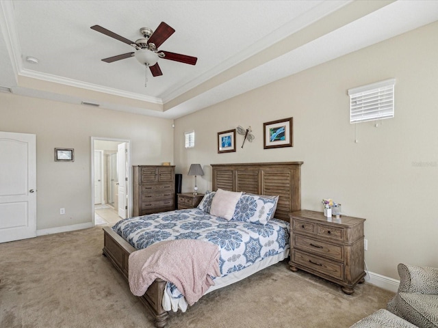 bedroom with a tray ceiling, crown molding, baseboards, and carpet floors