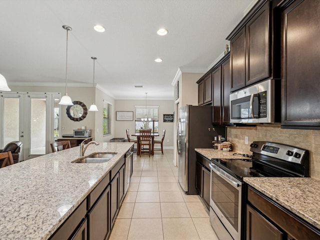 kitchen featuring light tile patterned flooring, a sink, stainless steel appliances, dark brown cabinetry, and backsplash