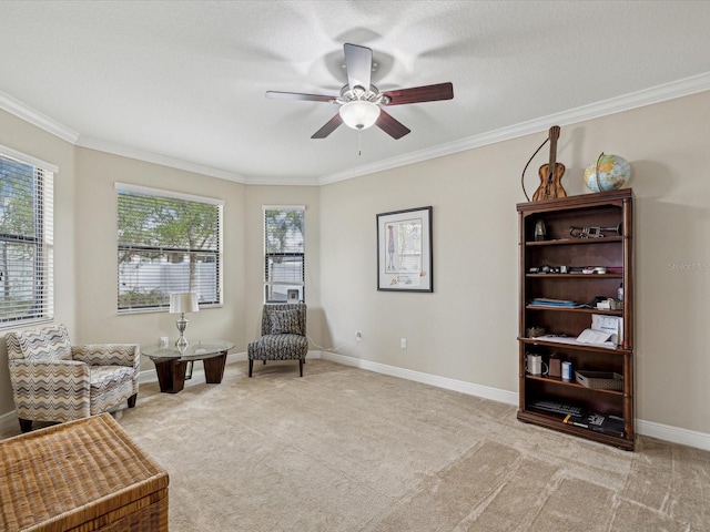 living area with light carpet, a ceiling fan, baseboards, and ornamental molding