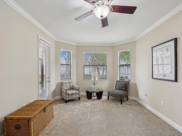 sitting room with baseboards, light colored carpet, and crown molding