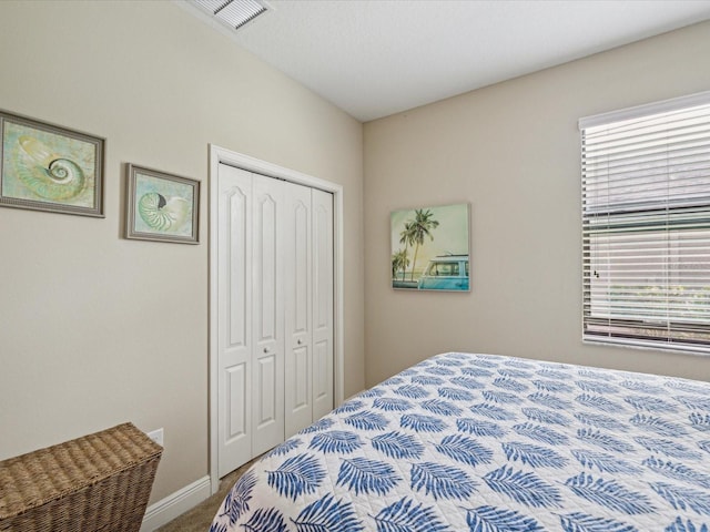 bedroom featuring a closet, visible vents, baseboards, and carpet floors