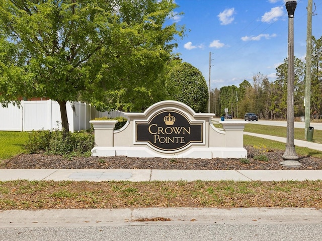 community / neighborhood sign featuring fence