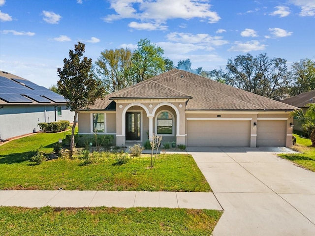 mediterranean / spanish home with stucco siding, an attached garage, concrete driveway, and a front yard