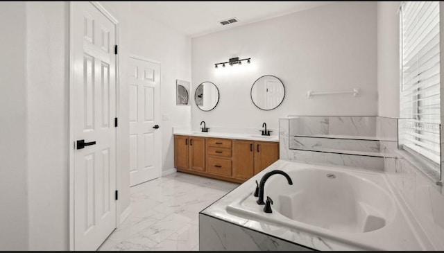 full bath featuring visible vents, a garden tub, double vanity, marble finish floor, and a sink