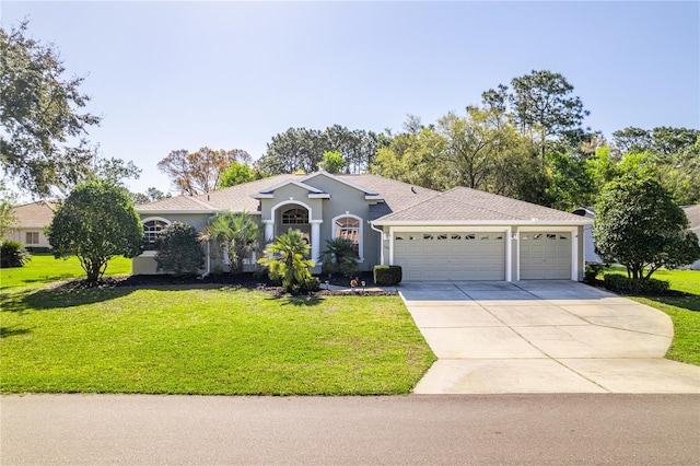 view of front of home featuring concrete driveway, a garage, a front yard, and stucco siding