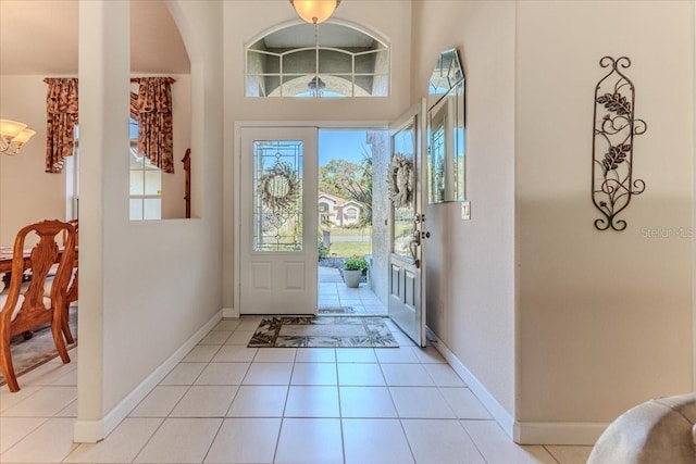 entrance foyer featuring light tile patterned floors, baseboards, and plenty of natural light