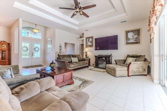 living room featuring visible vents, crown molding, ceiling fan, a tray ceiling, and light tile patterned flooring