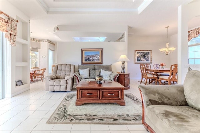 living room featuring a chandelier, a skylight, a tray ceiling, and light tile patterned flooring