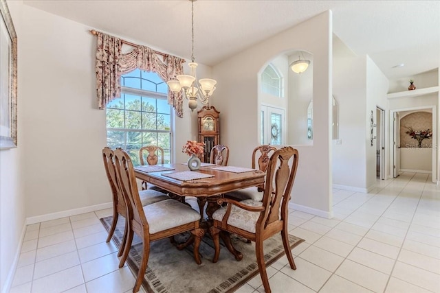 dining area with light tile patterned floors, baseboards, and an inviting chandelier