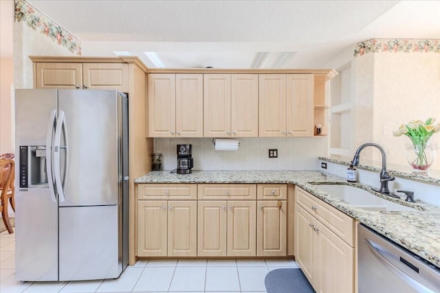 kitchen featuring light brown cabinets, a sink, appliances with stainless steel finishes, light tile patterned floors, and decorative backsplash