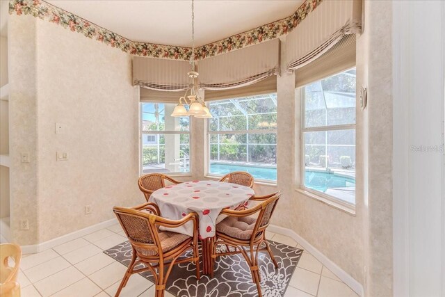 dining room with light tile patterned floors, a healthy amount of sunlight, and baseboards