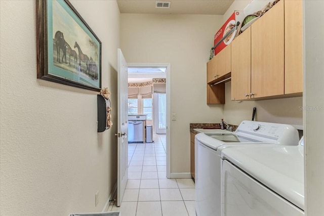 laundry room featuring light tile patterned floors, baseboards, cabinet space, a sink, and washer and clothes dryer