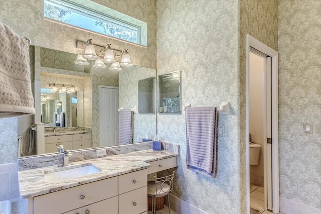 bathroom featuring wallpapered walls, tile patterned floors, vanity, and baseboards