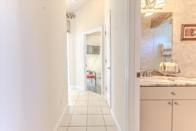 hall featuring light tile patterned floors and baseboards