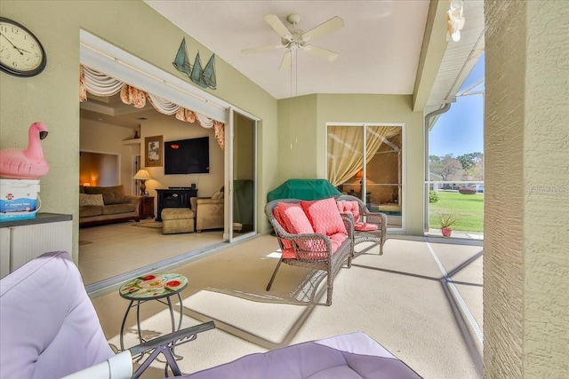 view of patio featuring glass enclosure and a ceiling fan