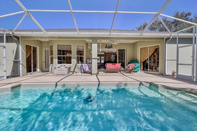 outdoor pool featuring a patio area, glass enclosure, and ceiling fan