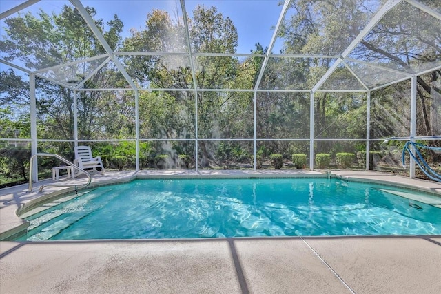 pool featuring glass enclosure and a patio area