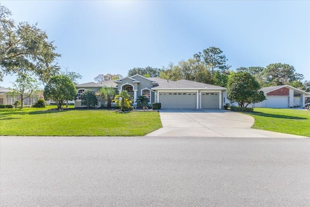 view of front of house with an attached garage, concrete driveway, and a front yard