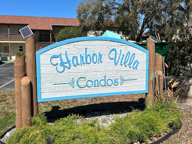 community / neighborhood sign featuring uncovered parking