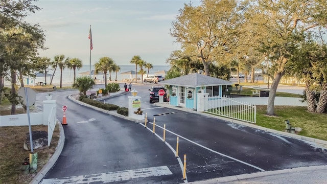 view of road featuring a gated entry, curbs, and traffic signs