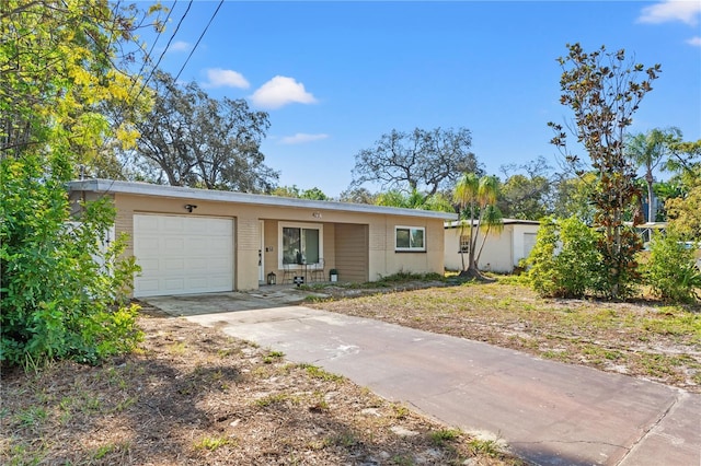 ranch-style house featuring concrete driveway and a garage