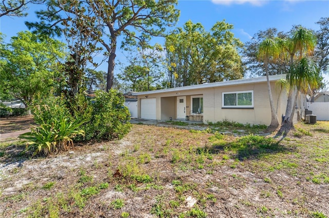 single story home featuring a garage and cooling unit