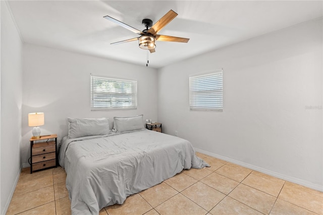 bedroom featuring light tile patterned floors, a ceiling fan, and baseboards