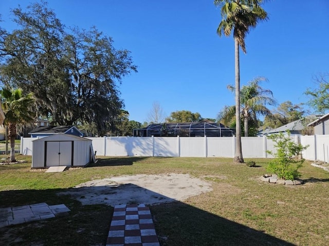 view of yard with a fenced backyard, an outdoor structure, and a shed