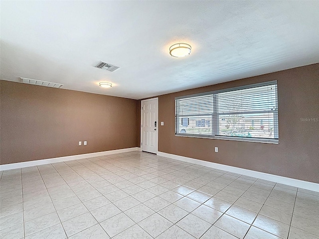 unfurnished room featuring visible vents, baseboards, and light tile patterned flooring