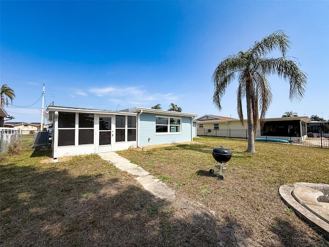 back of house with a yard, fence, and a sunroom