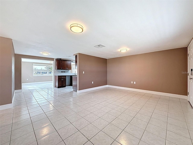 unfurnished living room featuring light tile patterned floors, baseboards, and visible vents