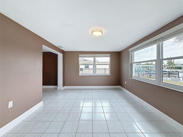 spare room with visible vents, baseboards, and light tile patterned flooring