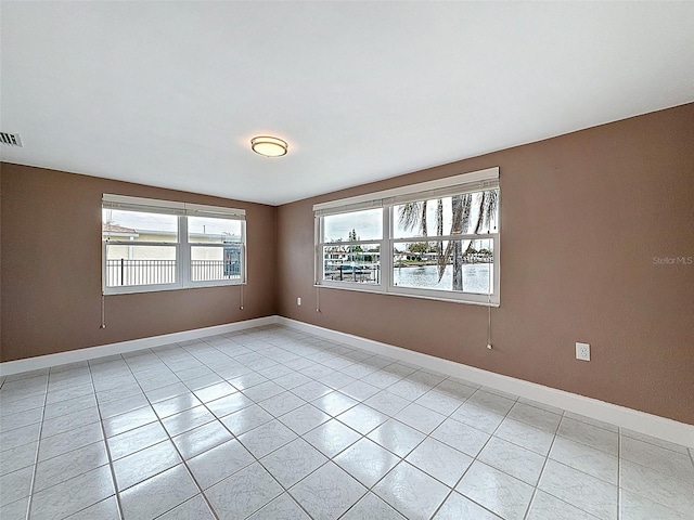 spare room with light tile patterned floors and baseboards