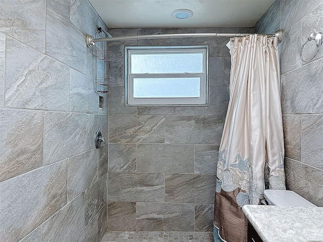 full bathroom featuring vanity and a tile shower