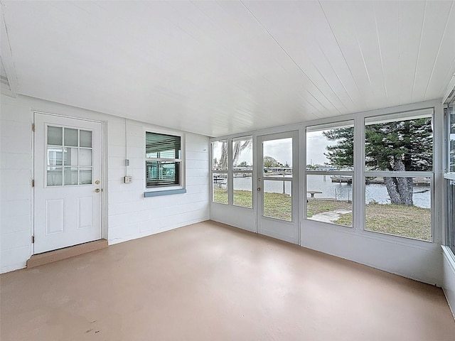 unfurnished sunroom featuring a water view