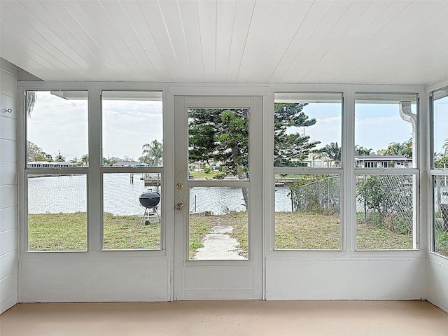 unfurnished sunroom featuring a water view and wooden ceiling