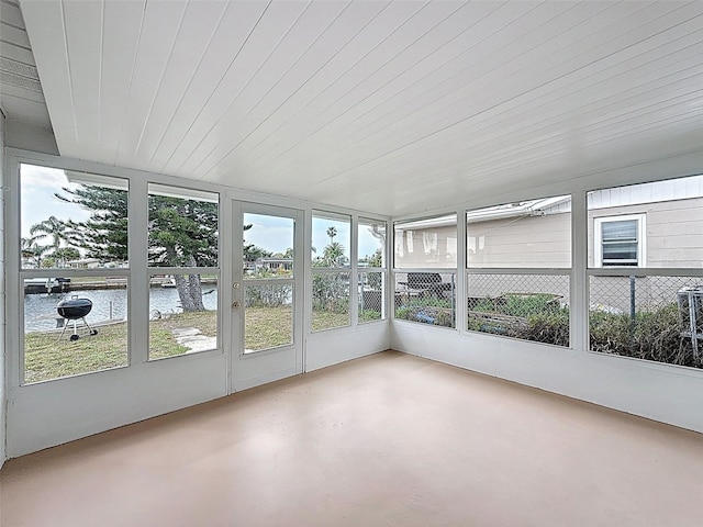 unfurnished sunroom with wood ceiling and a water view