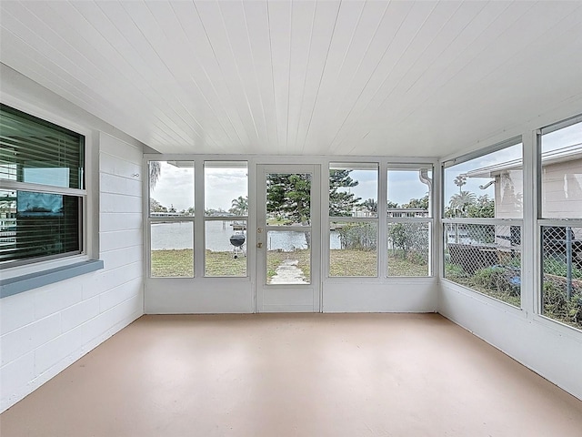 unfurnished sunroom featuring a water view