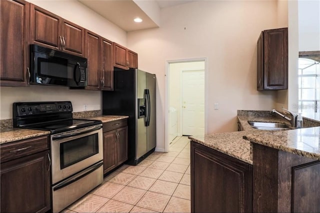 kitchen featuring electric range, refrigerator with ice dispenser, a sink, dark brown cabinetry, and black microwave