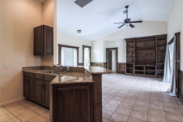 kitchen featuring ceiling fan, a peninsula, dark brown cabinets, and a sink