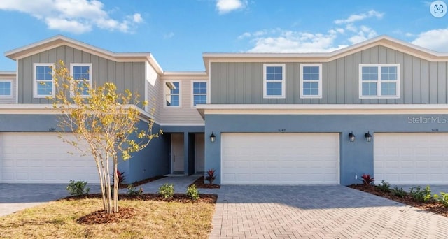 multi unit property with decorative driveway, an attached garage, and stucco siding