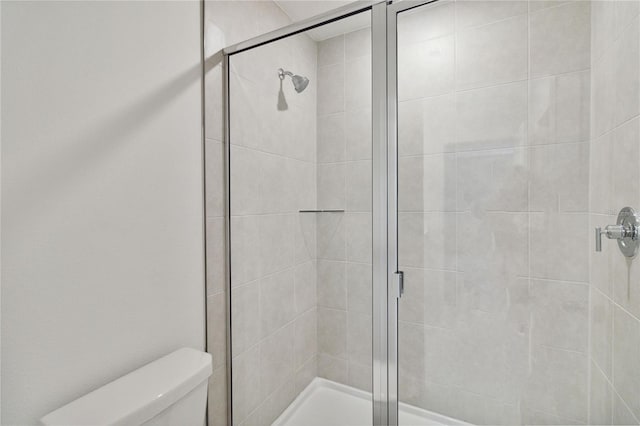 bathroom with toilet and a stall shower