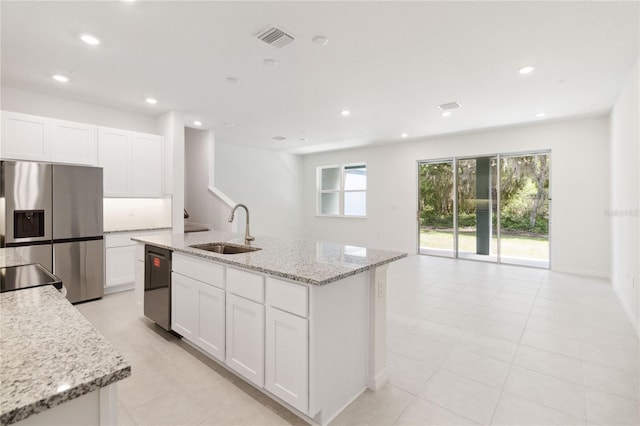 kitchen featuring white cabinets, stainless steel fridge, a sink, visible vents, and dishwashing machine