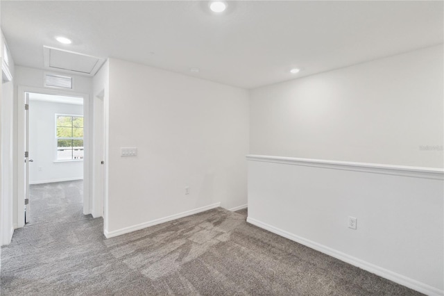 carpeted empty room featuring recessed lighting, attic access, baseboards, and visible vents