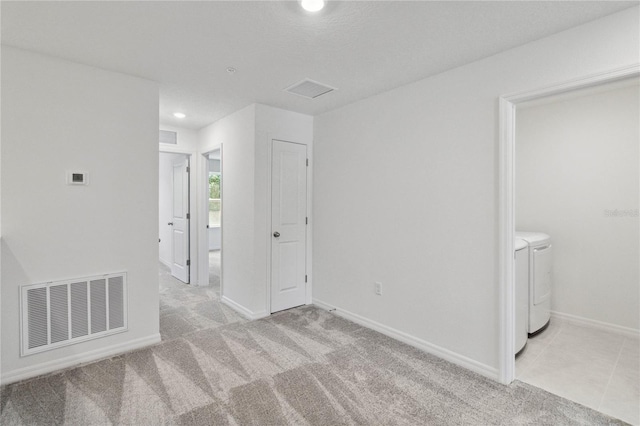 unfurnished bedroom featuring visible vents, washing machine and dryer, baseboards, light carpet, and recessed lighting