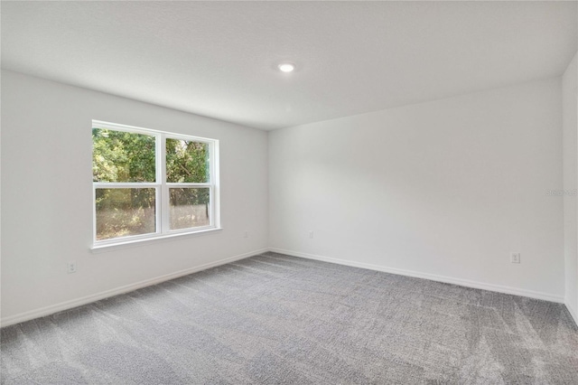 carpeted empty room featuring recessed lighting and baseboards